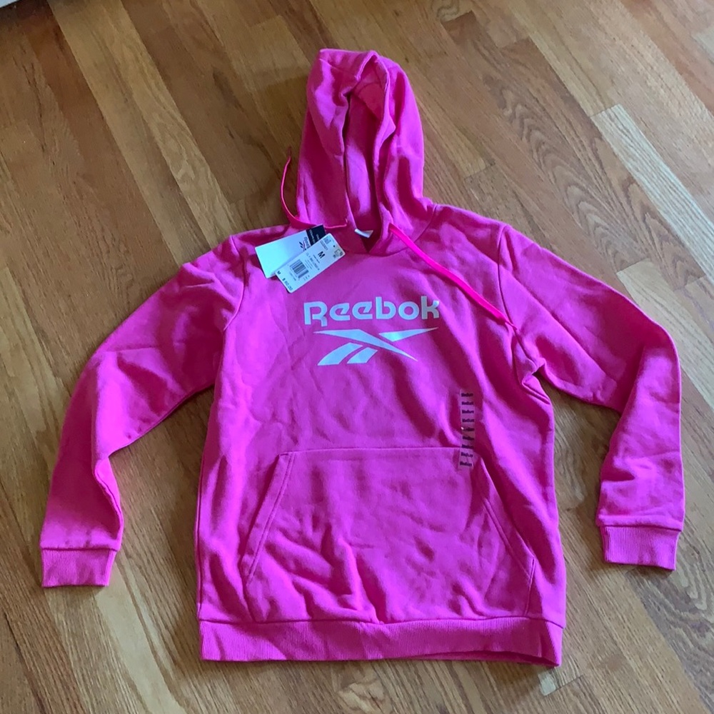Reebok pink sweatshirt never worn and tags attached. Front pocket, size medium